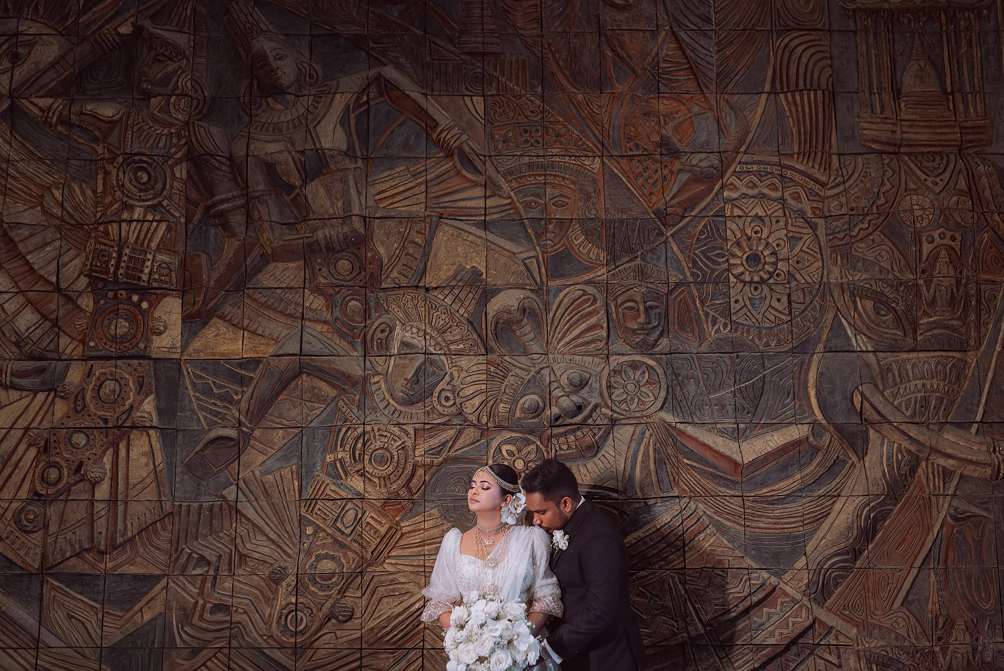 Intimate wedding portrait with a moody sunset over a rugged coastline.